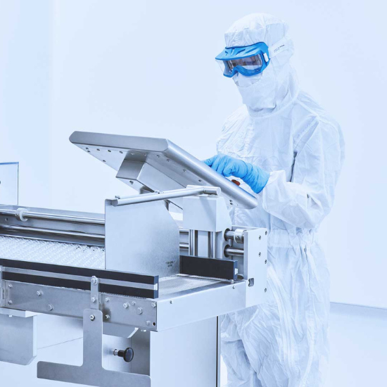 1080x1080 Website Images (800 × 800 px) (20).png Person in head-to-toe PPE operating machinery with a touch screen.