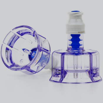 Two angles of a clear vial adapter with a light gray background.
