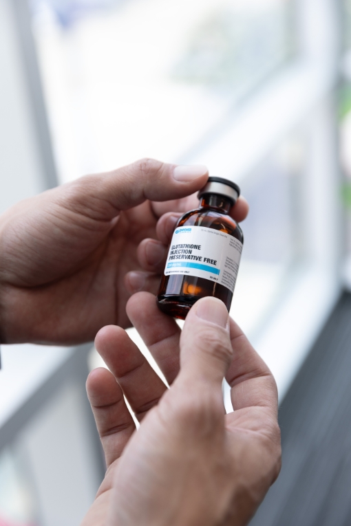 Hands holding a vial of Empower Pharmacy's injectable medication.