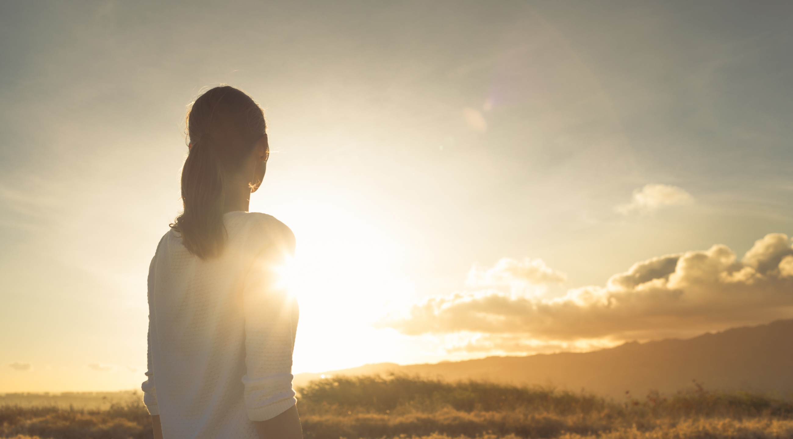 A woman looking into the sunset.