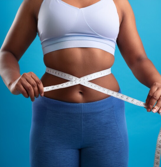 woman holding a tape measure around her waist